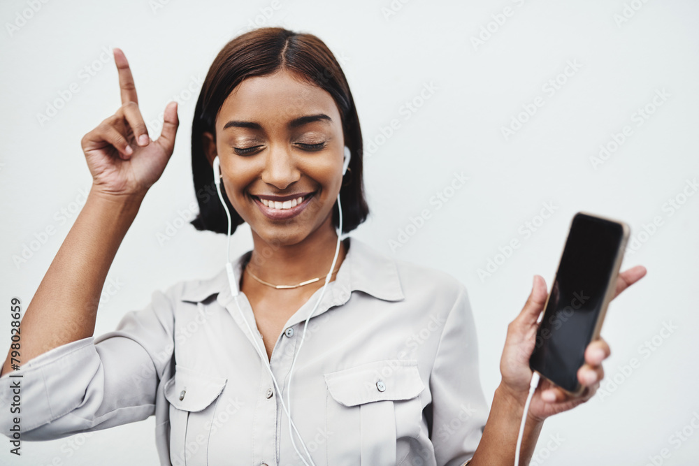 Phone, music and Indian girl dance with earphones in studio for fun, track or streaming audio on white background. Smartphone, app or happy gen z model smile for sign up playlist, radio or podcast Phone, music and Indian girl dance with earphones in studio for fun, track or streaming audio on white background. Smartphone, app or happy gen z model smile for sign up playlist, radio or podcast