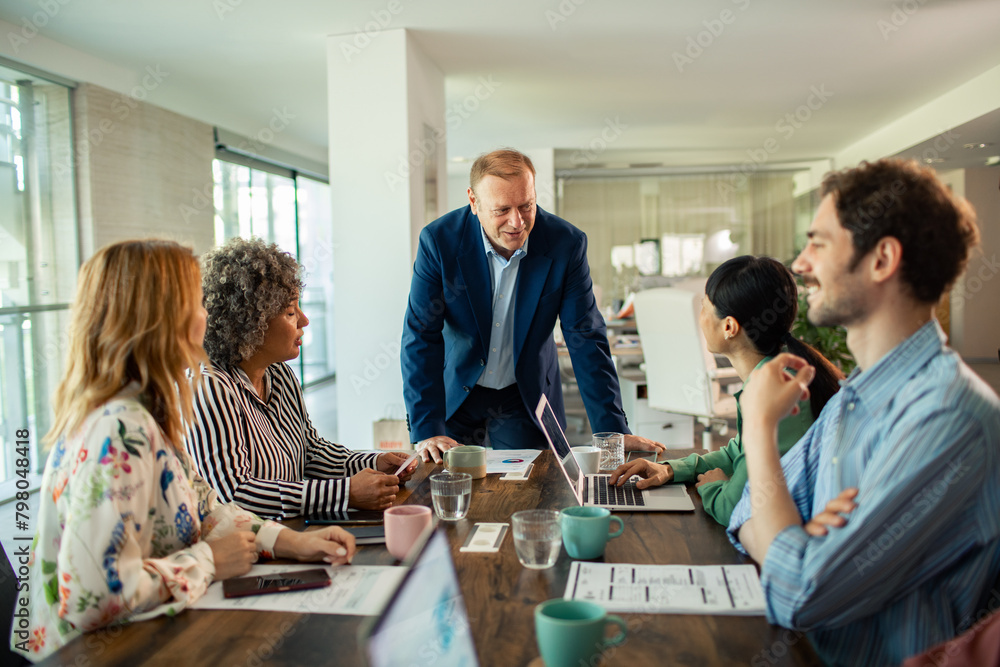 Business meeting in modern office with team of diverse employees discussing project Business meeting in modern office with team of diverse employees discussing project