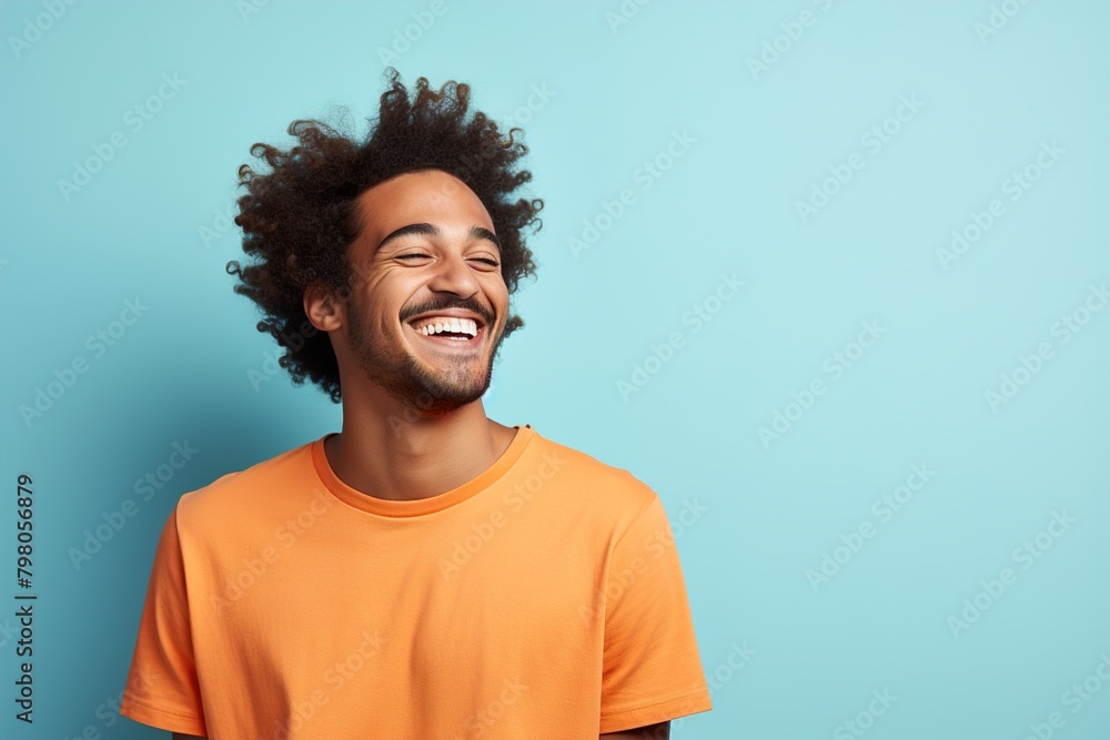 A man with curly hair is smiling and wearing an orange shirt A man with curly hair is smiling and wearing an orange shirt