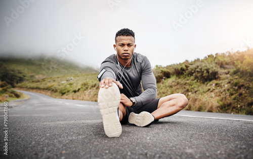 Man, portrait and stretching legs on road for fitness or hike with muscle preparation for workout. Serious, wellness and motivation for mindset with training, music and energy for cardio or health