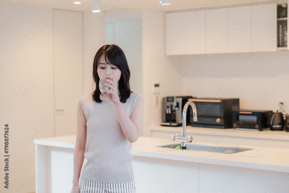 家で水を飲む若い女性 家で水を飲む若い女性