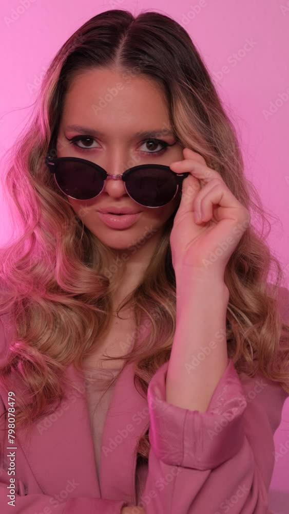 Portrait of a girl with beautiful makeup on a pink background. Fashion model. Vertical video. Portrait of a girl with beautiful makeup on a pink background. Fashion model. Vertical video.