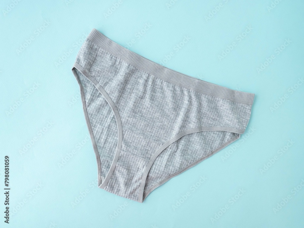 Women's underwear. Grey cotton underpants on a blue background. A piece of clothing for a person Women's underwear. Grey cotton underpants on a blue background. A piece of clothing for a person