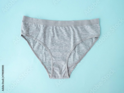 Women's underwear. Grey cotton underpants on a blue background. A piece of clothing for a person