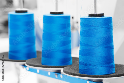 Spools of blue color threads closeup, spinning machine