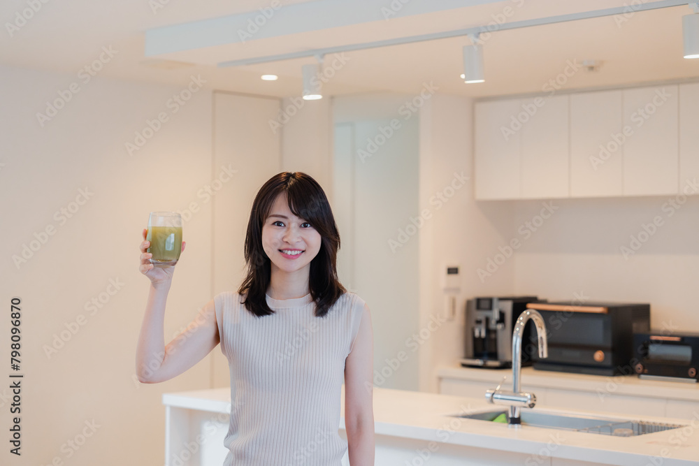 家でスムージーを飲む若い女性 家でスムージーを飲む若い女性