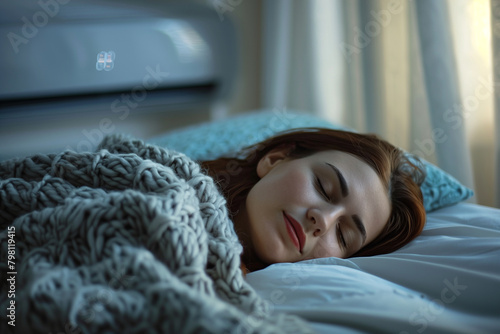 Woman sleeping peacefully under a blanket with the air conditioner on