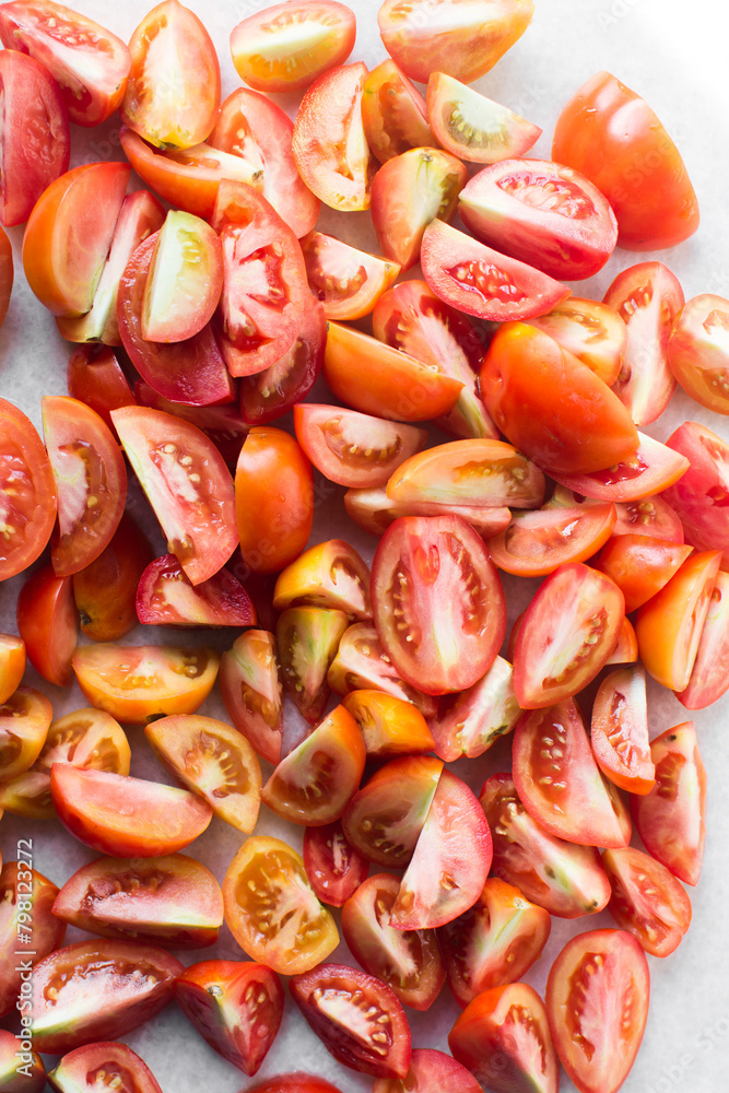 Overhead view of chopped tomatoes on a white granite countertop, Top view of chopped orange and red tomatoes on a white chopping board