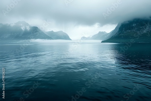b'Misty fjord landscape with steep mountains and dark water'