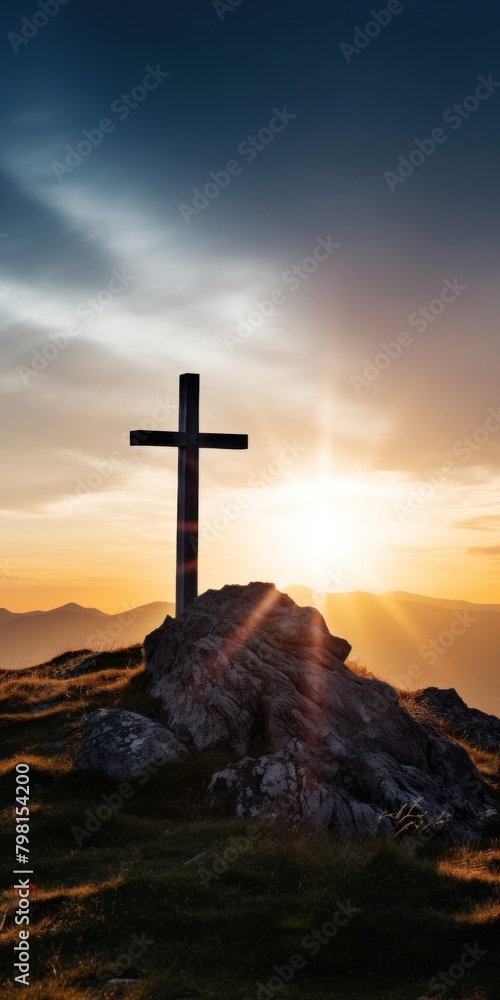 a cross on a hill with the sun shining through the clouds