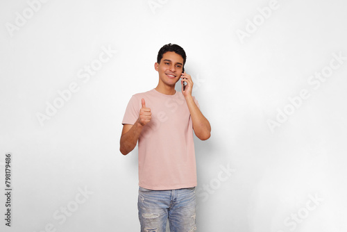young man very happy using his smartphone and saying with his hand that everything is ok