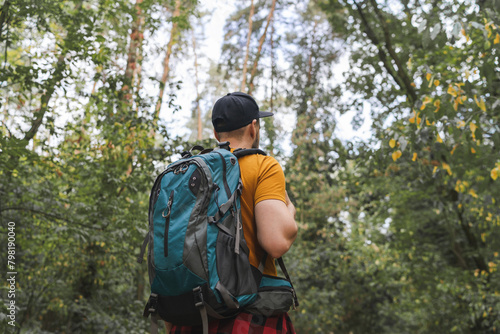 Wallpaper Mural Young male tourist walking in the middle of the early autumn forest with big travel backpack Torontodigital.ca
