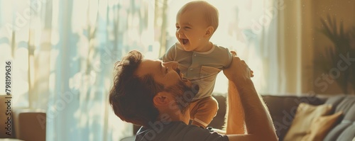 father embracing his giggling toddler son in a warm sunlit home. photo