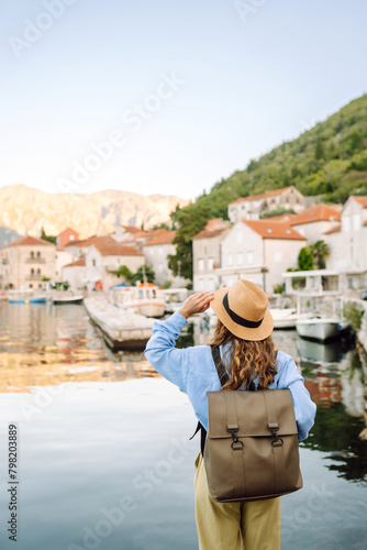 Happy young woman standing on bridge enjoys the view of the city. Back view. Europe travel. Lifestyle, vacation, tourism, nature, active life.