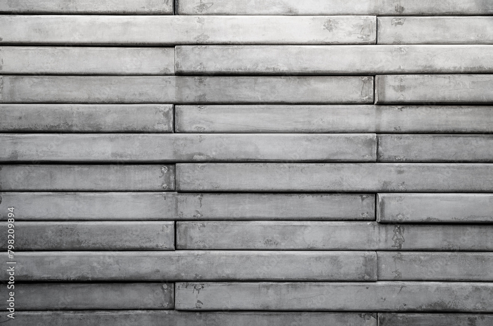 Front view of a wall made of gray concrete slates. Abstract high resolution full frame textured background in black and white, copy space.
