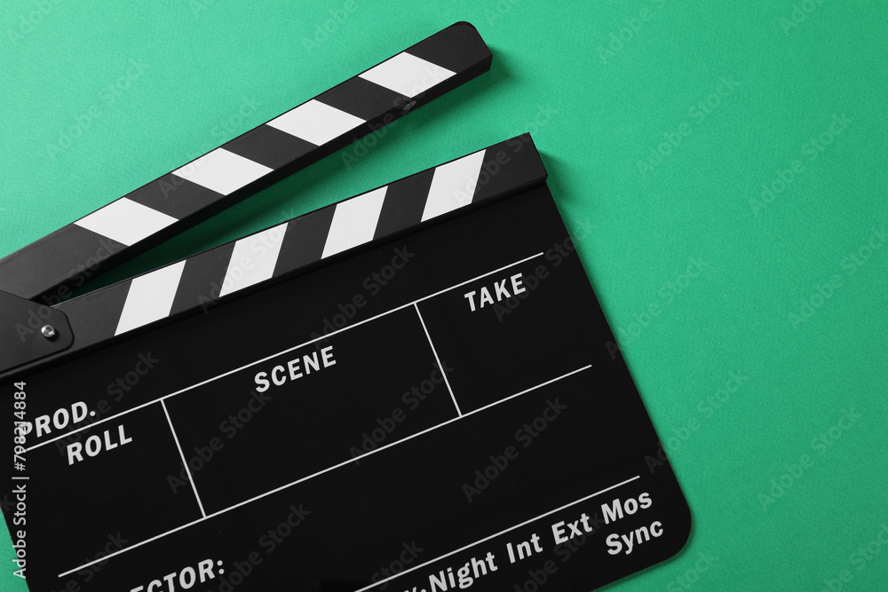 Obraz premium Clapperboard on green background, top view. Space for text