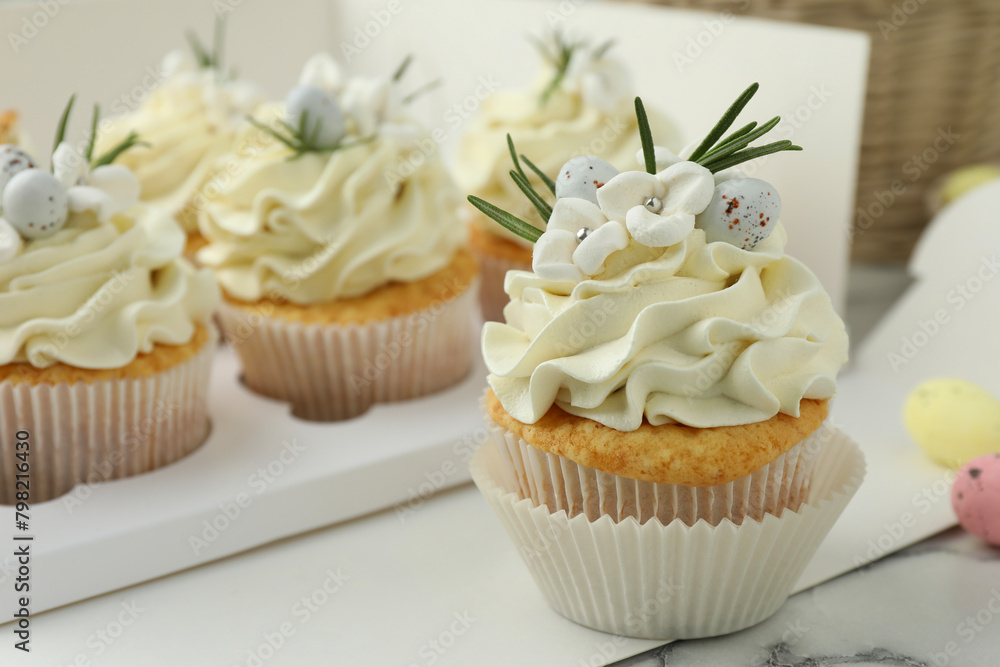 Tasty Easter cupcakes with vanilla cream on table, closeup Tasty Easter cupcakes with vanilla cream on table, closeup