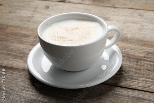 Aromatic coffee in cup on wooden table