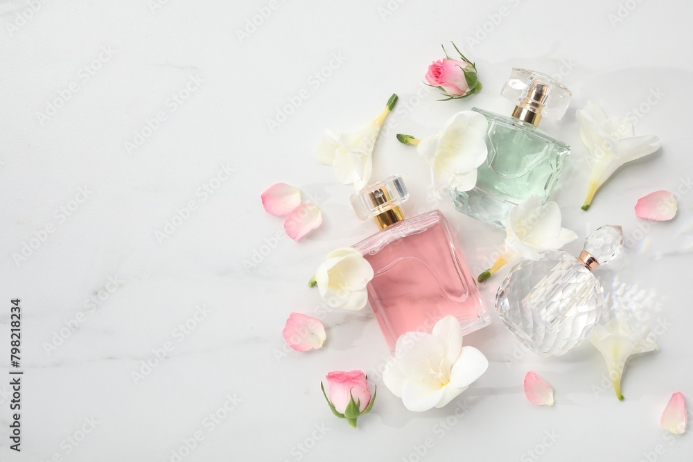 Luxury perfume and floral decor on white marble table, flat lay. Space for text Luxury perfume and floral decor on white marble table, flat lay. Space for text