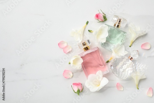 Luxury perfume and floral decor on white marble table  flat lay. Space for text