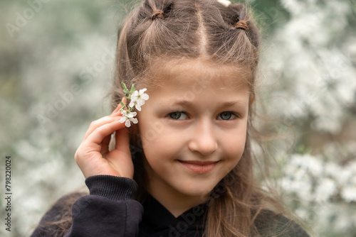 portrait of a little girl in a blooming garden