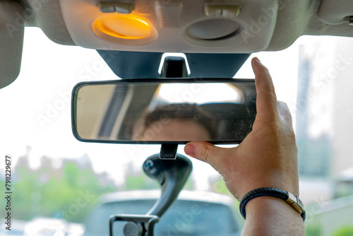 Interior mirror of a passenger car. Adjusting the mirror in the car. Driving test.