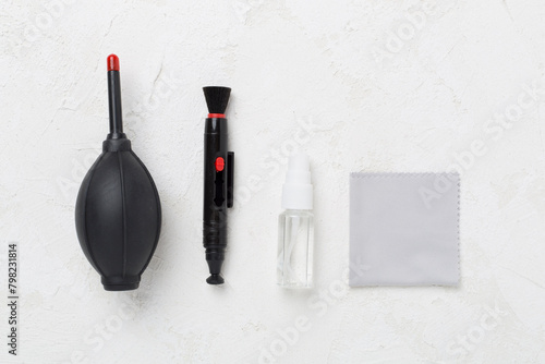 Different camera cleaning tools on white background, top view