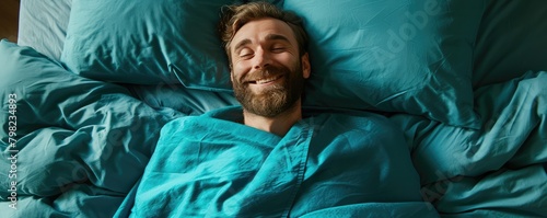 Man relaxing in bed with hands behind head photo