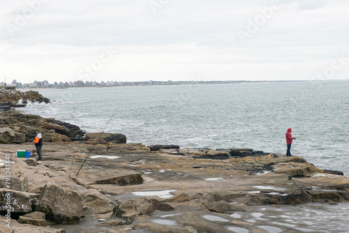 Fisher fishing in Mardel Plata coast Sea and gray sky photo