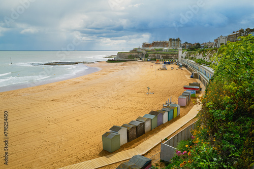 Beach huts along the beautiful sandy Viking Bay beach in Broadstairs, Kent, UK during a cloudy, rainy spring day. .