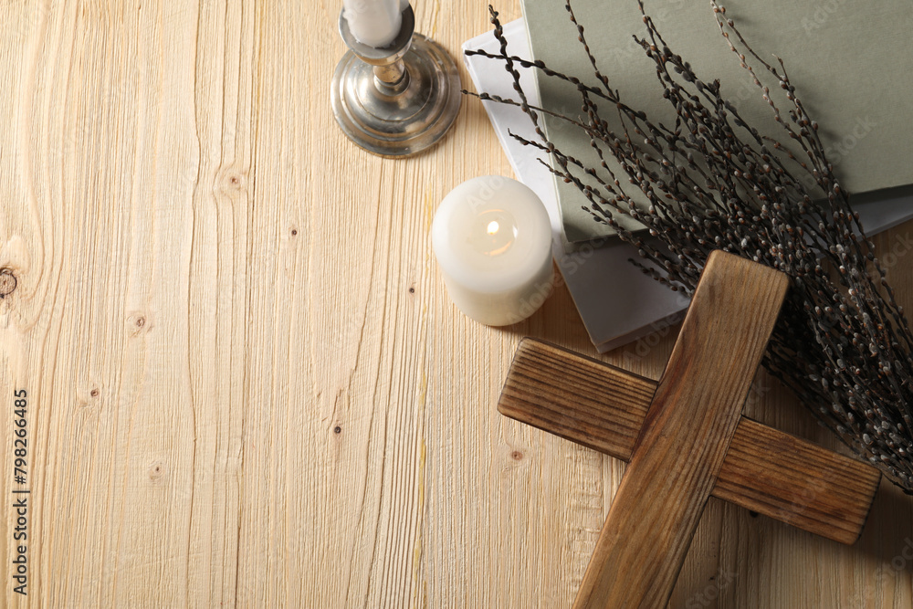 Cross, candles, books and willow branches on wooden table, flat lay. Space for text Cross, candles, books and willow branches on wooden table, flat lay. Space for text