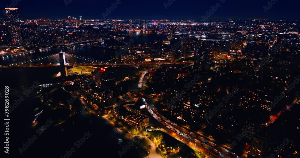 Lively traffic in never-sleeping New York at night. Scenic view of metropolis and waterscape of the East River from top view. Lively traffic in never-sleeping New York at night. Scenic view of metropolis and waterscape of the East River from top view.