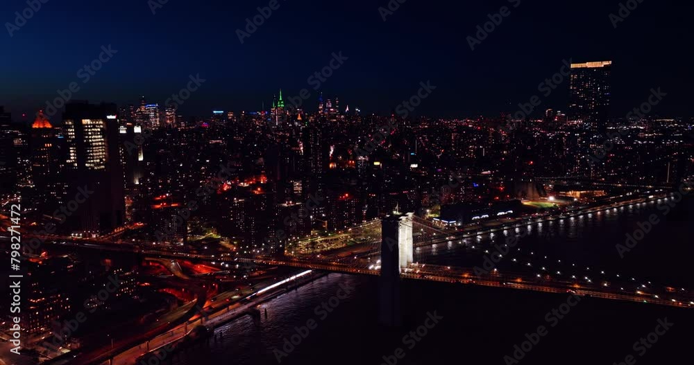 Enormous panorama of New York with sparkling lights. Well-lit Brooklyn Bridge over the East River at night. Top view. Enormous panorama of New York with sparkling lights. Well-lit Brooklyn Bridge over the East River at night. Top view.