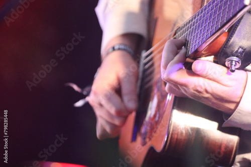 close up person playing acoustic guitar at a concert