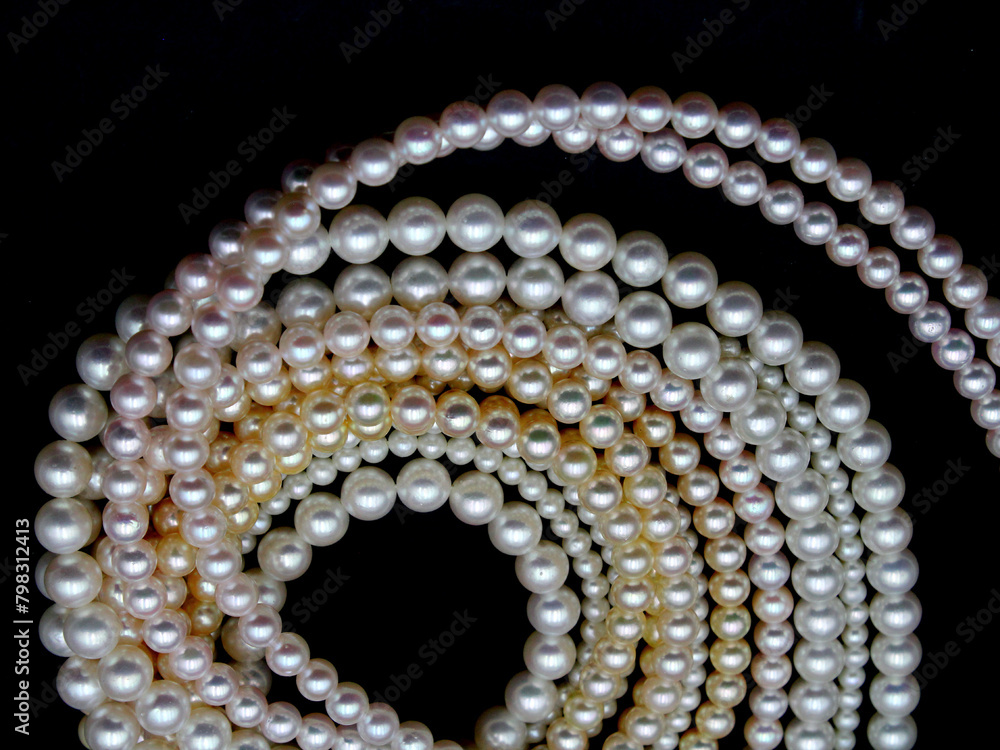 Expensive and luxurious Japanese saltwater Akoya pearls on strands of white, pink and golden organic gems ready to be made into necklaces and sold in jewelry store. Expensive and luxurious Japanese saltwater Akoya pearls on strands of white, pink and golden organic gems ready to be made into necklaces and sold in jewelry store.
