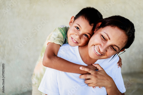 Happy Latin mother having fun with her son child. Family relationship and love concept. Focus on mom face