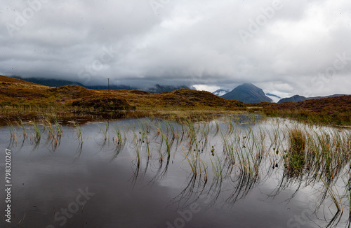 Mountain reflection in water with clouds in Scotland, Sligachan, Isle of Skye. marsh and forest in the valley surrounded by mountains