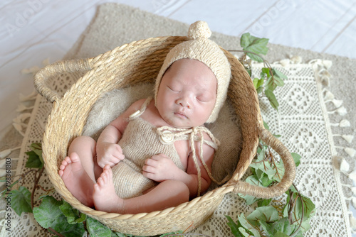 Newborn photo of an 18-day-old Taiwanese baby living in Taichung wearing a beige costume and sleeping on a basket 台中に住む生後18日の台湾人の赤ちゃんがベージュの衣装を着てかごの上で寝ているニューボーンフォト 