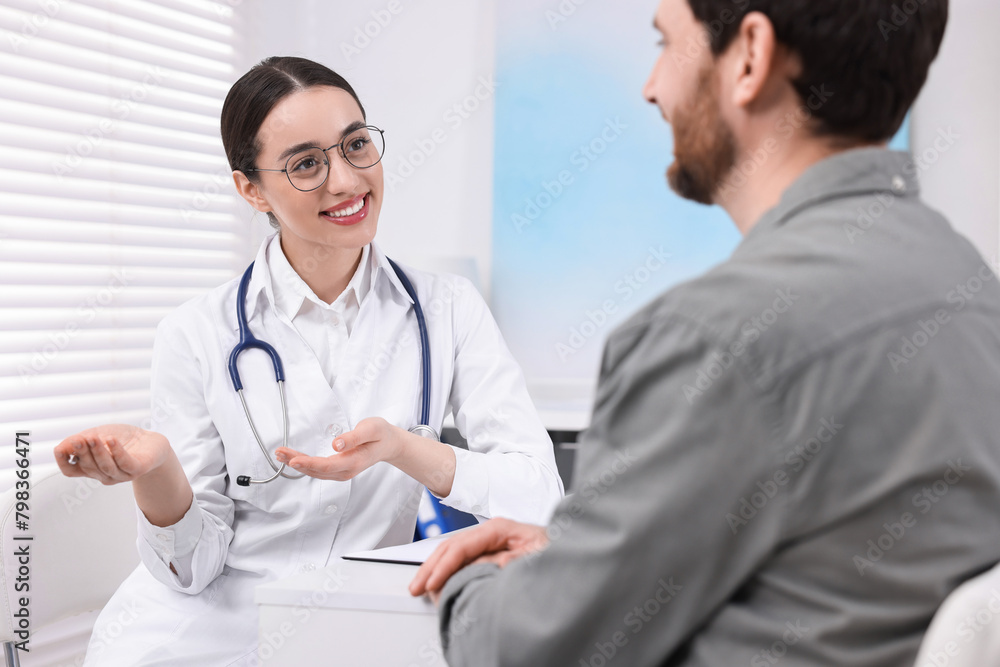 Doctor consulting patient during appointment in clinic Doctor consulting patient during appointment in clinic
