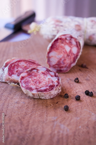 Cured salami sausage, Italian cuisine, isolated on wooden background