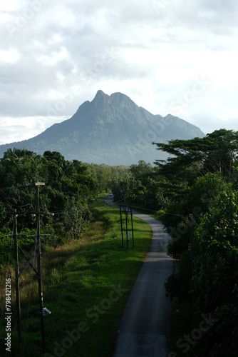 A picture of jungle and road with misty Gunung Santubong insight in the morning.