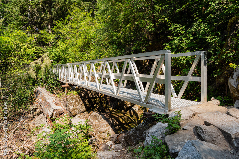 Metal bridge over the little river or mountain creek and hiking trail in provincial park Fraser Valley British Columbia