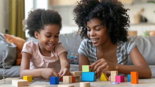 Mother and daughter are building blocks indoors