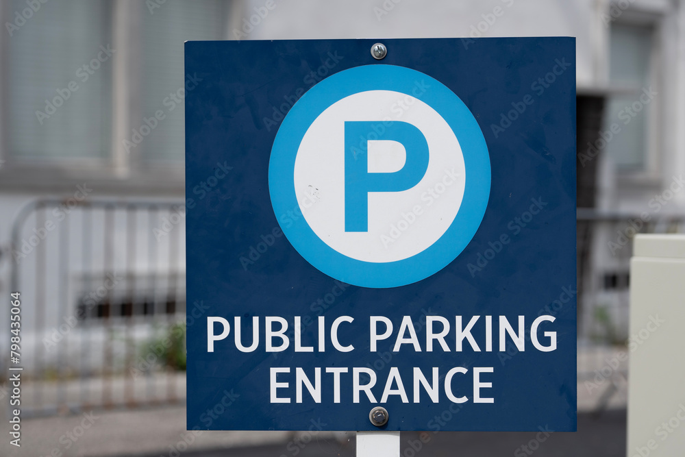 blue public parking entrance sign in front of a city lot blue public parking entrance sign in front of a city lot