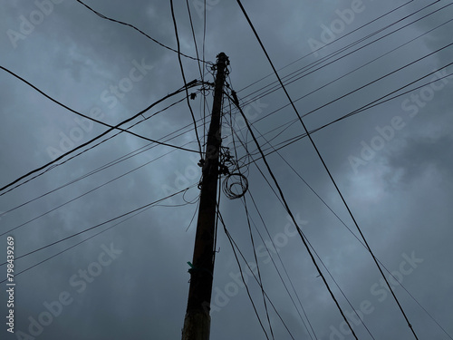 Power supply pole and cables, with dark cloudy sky background photo