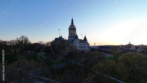 Drone video rising up for aerial view of the Connecticut State Capitol building perched atop its hill overlooking Bushnell Park and downtown Hartford at dusk photo