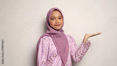 Indonesian teenage girls wearing kebaya and hijab gesture showing open palms