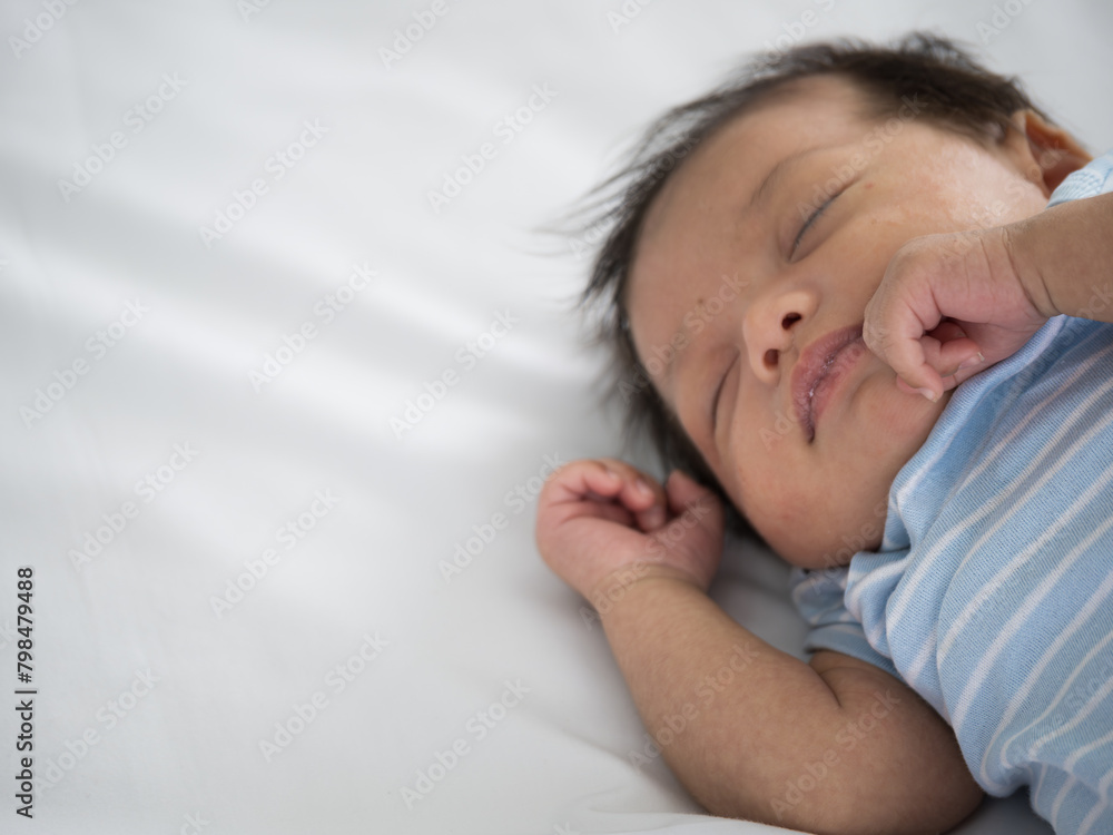 Portrait of three weeks Australian Asian newborn baby or infant lying on the white bed and close her eyes.. Portrait of three weeks Australian Asian newborn baby or infant lying on the white bed and close her eyes..