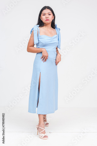Elegant young Asian woman in powder blue dress isolated on white