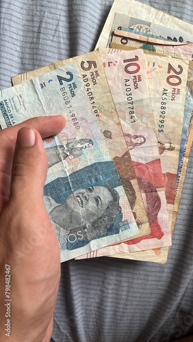 Hand holding some colombian Pesos banknotes photo